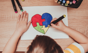 enfant en train de dessiné un coeur, découpé en 3 pièces de puzzle