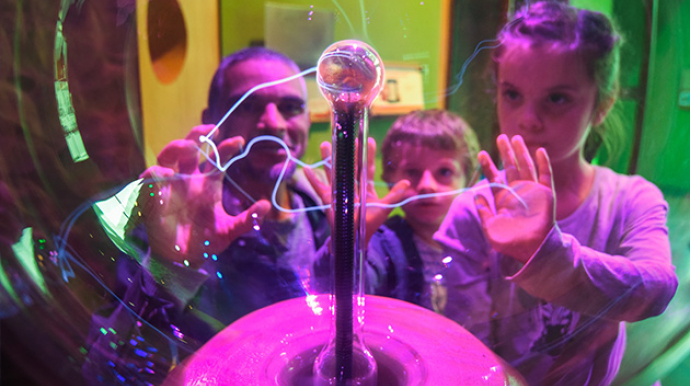 Photo d'une famille utilisant une boule à plasma