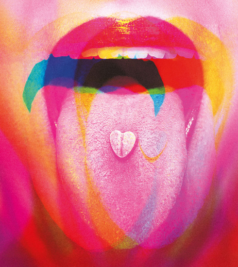 langue tirée, avec un "bonbon" sur la langue. l'image est rose et floue